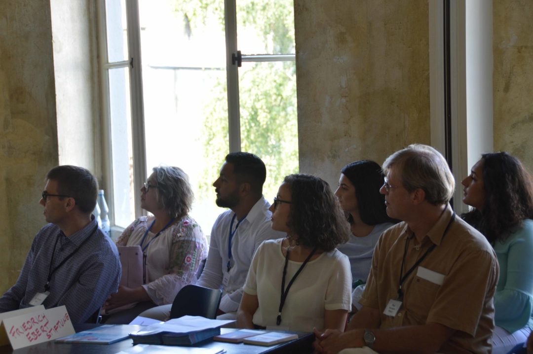 Participants sit on chairs and listen attentively during a lecture.