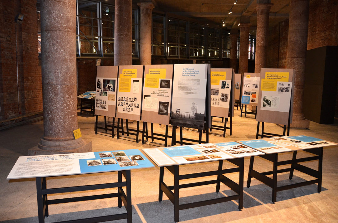 Eindrücke der Ausstellung in Nürnberg. Die Ausstellung besteht aus vielen einzelnen Tafeln, die sich jeweils einem Themenschwerpunkt widmen. Die Tafeln sind entweder als Tisch gestaltet oder auf einer Staffelei angebracht.