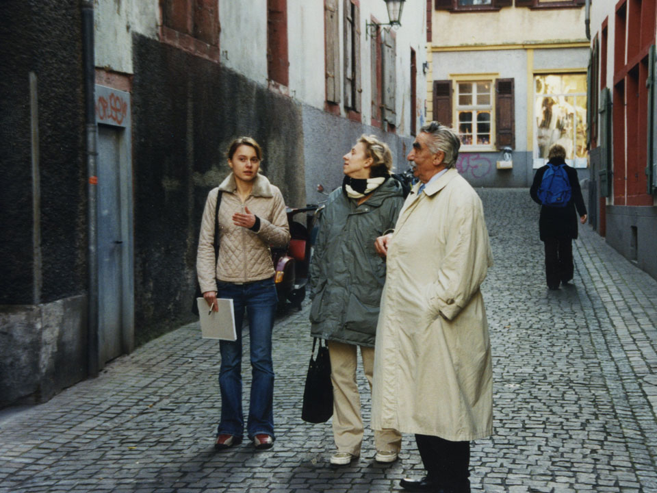 Der Sinto Herbert Birkenfelder berichtete den Auszubildenen über seine Kindheit in der Heidelberger Altstadt. Er steht zusammen mit zwei Teilnehmerinnen in einer Gasse der Heidelberger Altstadt.