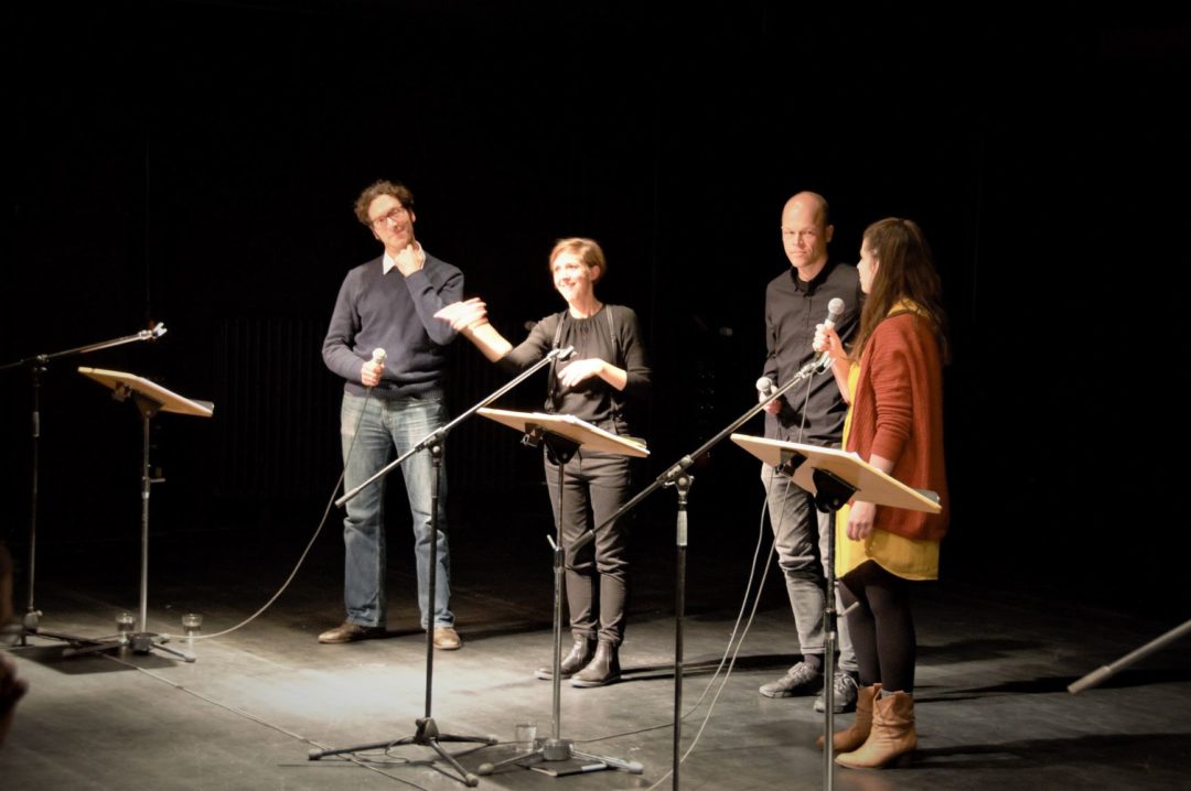 Zwei Männer und zwei Frauen während der Lesung der "NSU-Monologe" auf einer Bühne. Vor ihnen stehen jeweils ein Mikrofon und ein Lesepult.