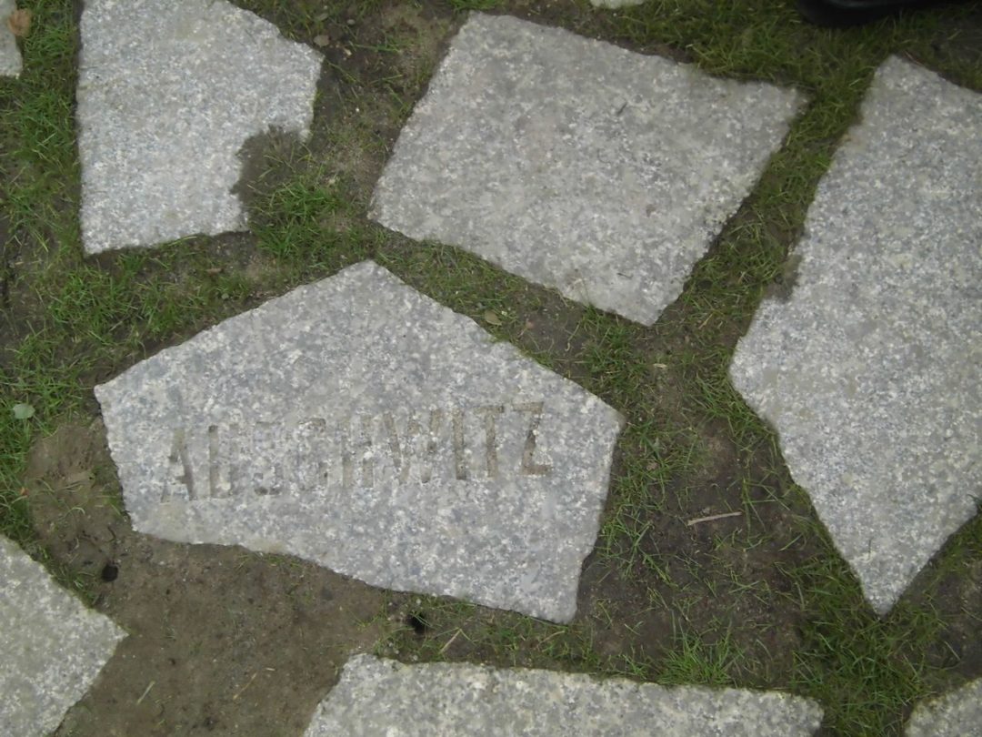 Graue Steinplatten mit eingravierten Namen von Konzentrationslagern.