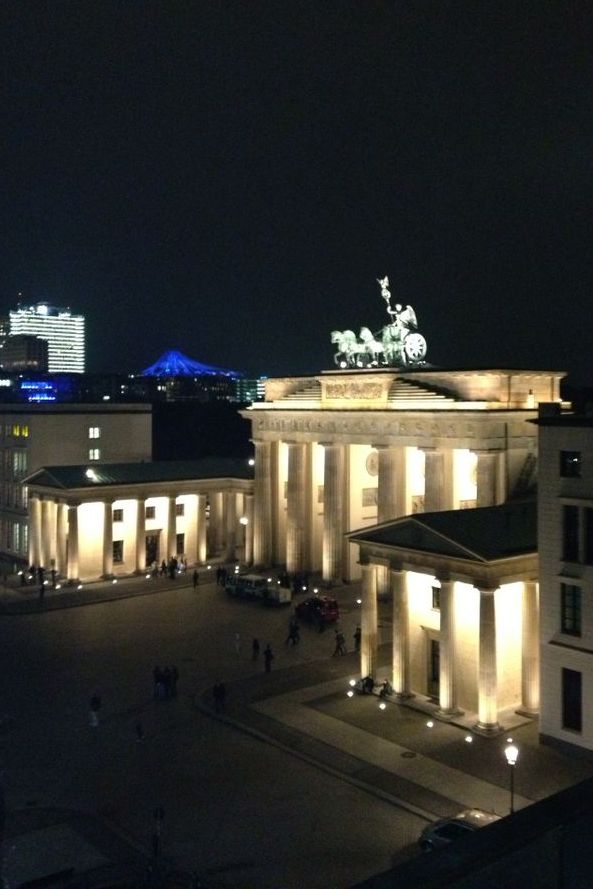 Blick auf das erleuchtete Brandenburger Tor bei Nacht.