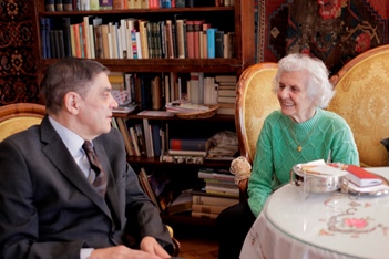 Romani Rose führte am 1. März 2014 in Budapest ein Interview mit der Holocaust-Überlebenden Éva Fahidi-Pusztai. Beide sitzen vor einer Bücherwand.