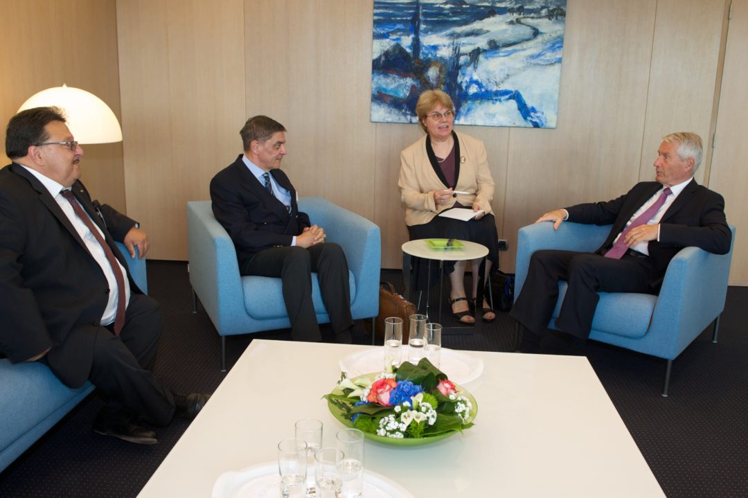 Jacques Delfeld, Romani Rose und Thorbjørn Jagland sitzen während eines Gesprächs auf Sesseln. Zwischen Romani Rose und Thorbjørn Jagland sitzt eine Dolmetscherin.