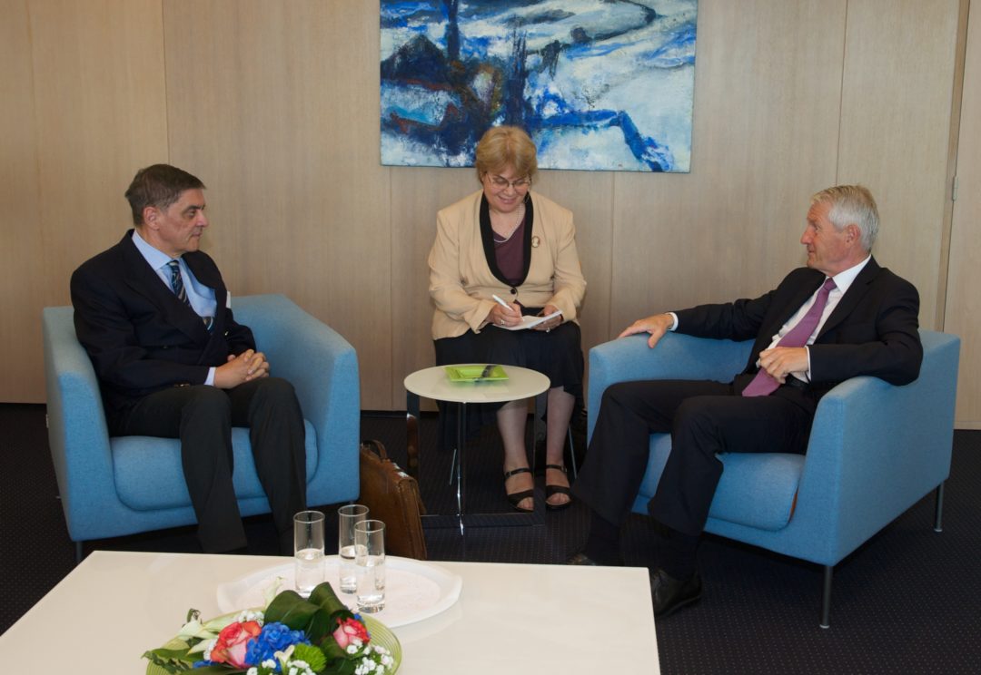 Romani Rose und Thorbjørn Jagland sitzen während eines Gesprächs in Sesseln gegenüber. Zwischen ihnen sitzt eine Dolmetscherin.