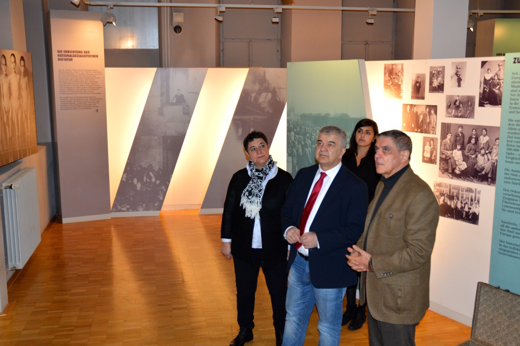 Der Bundesvorsitzende der Türkischen Gemeinde in Deutschland Gökay Sofuoğlu wird mit dem baden-württembergischen Vorstandsmitglied Oya Poyraz von Romani Rose durch die Dauerausstellung des Dokumentationszentrums geführt.