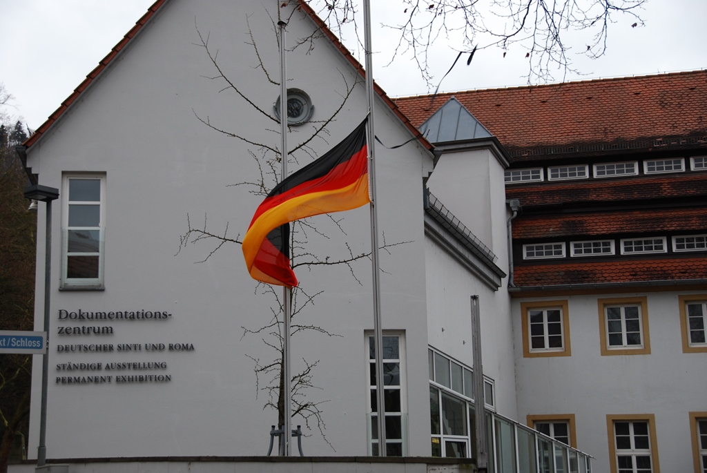 Vor dem Dokumentations- und Kulturzentrum weht eine Deutschlandflagge auf Halbmast.