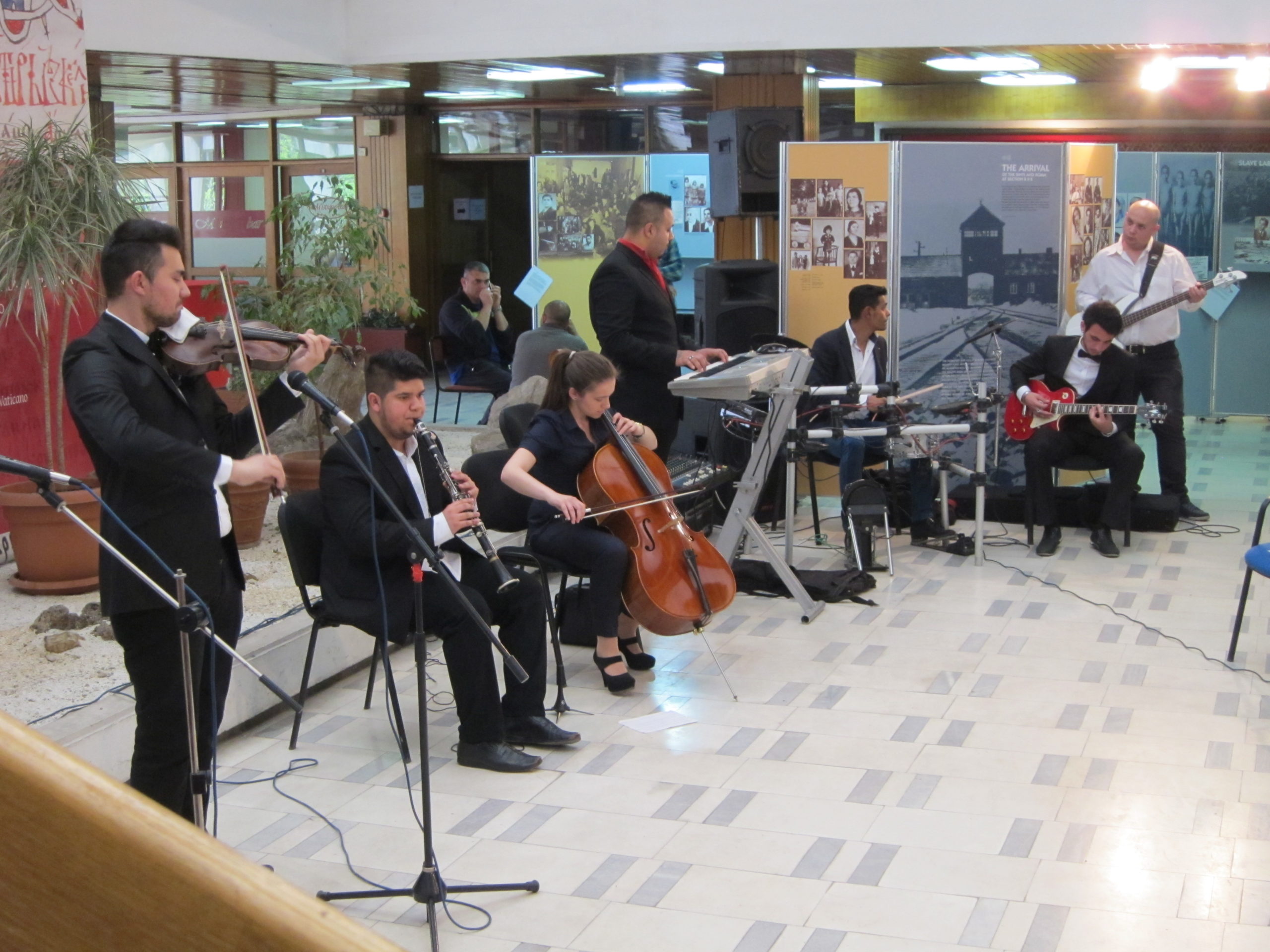 Eine Gruppe von sieben Musikern spielt bei der Ausstellungseröffnung.