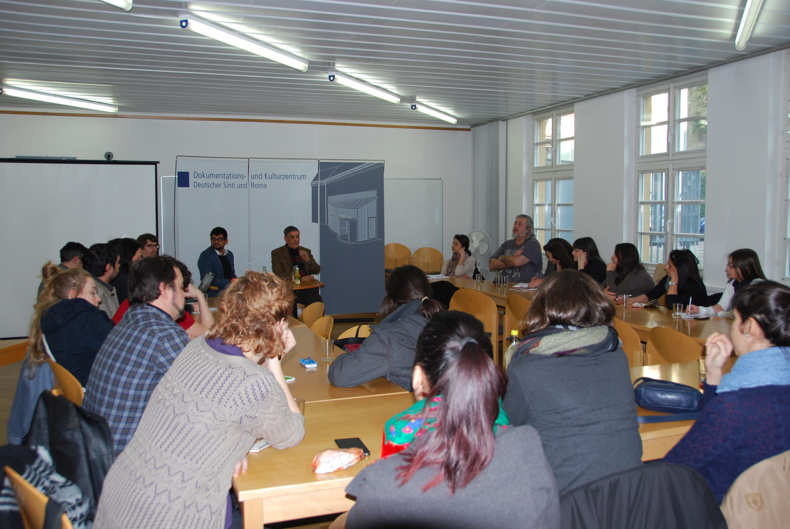 Teilnehmer des Workshops sitzen zusammen im Besprechungsraum des Dokumentationszentrums.