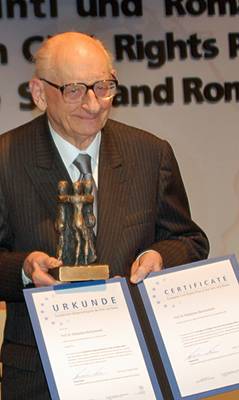 Władysław Bartoszewski bei der Preisverleihung. Er hält in seinen Händen die Skultpur und die Preisurkunde.
