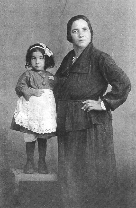 Sonja und Katharina Birkenfelder auf einem historischen Foto in schwarz-weiß. Die kleine Sonja steht auf einem Hocker neben ihrer Mutter.