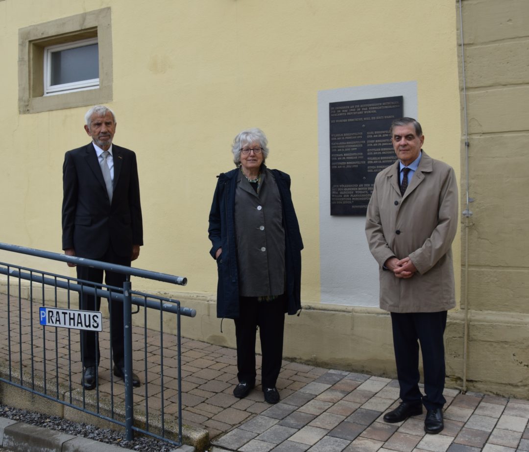 Manfred Lautenschläger, Elsbeth Wagner und Romani Rose stehen vor der Gedenktafel zur Erinnerung an die deportierten Sinti aus Hoffenheim.