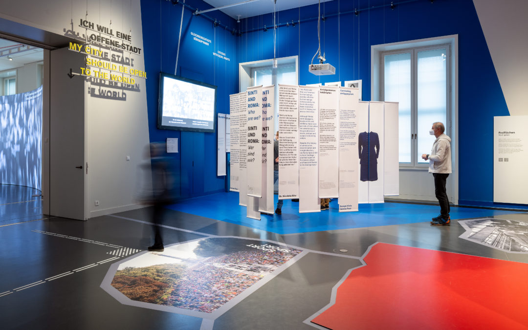 Blick in die Ausstellung "Gleichberechtigte Bürger*innen" in BERLIN GLOBAl im Humdoldt Forum. Zu sehen sind großformatige Ausstellungstafeln auf einer Freifläche.