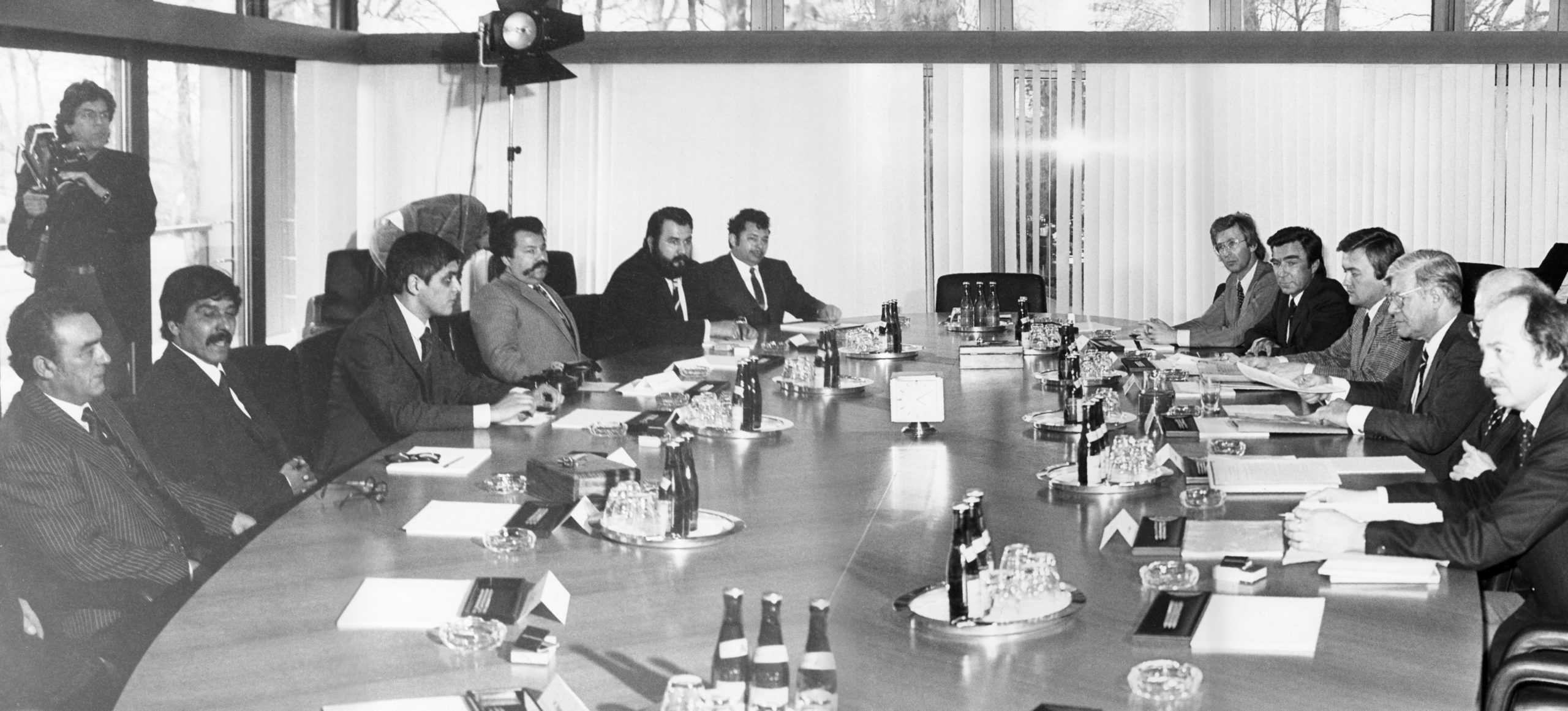 Die Delegation unter Leitung von Romani Rose am 17. März 1982 im Bundeskanzleramt in Bonn bei dem Gespräch mit Bundeskanzler Helmut Schmidt. An einem großen Besprechungstisch sitzen sich links die Delegation und rechts Bundeskanzler Schmidt zusammen mit Vertretern der Bundesreigerung gegenüber.