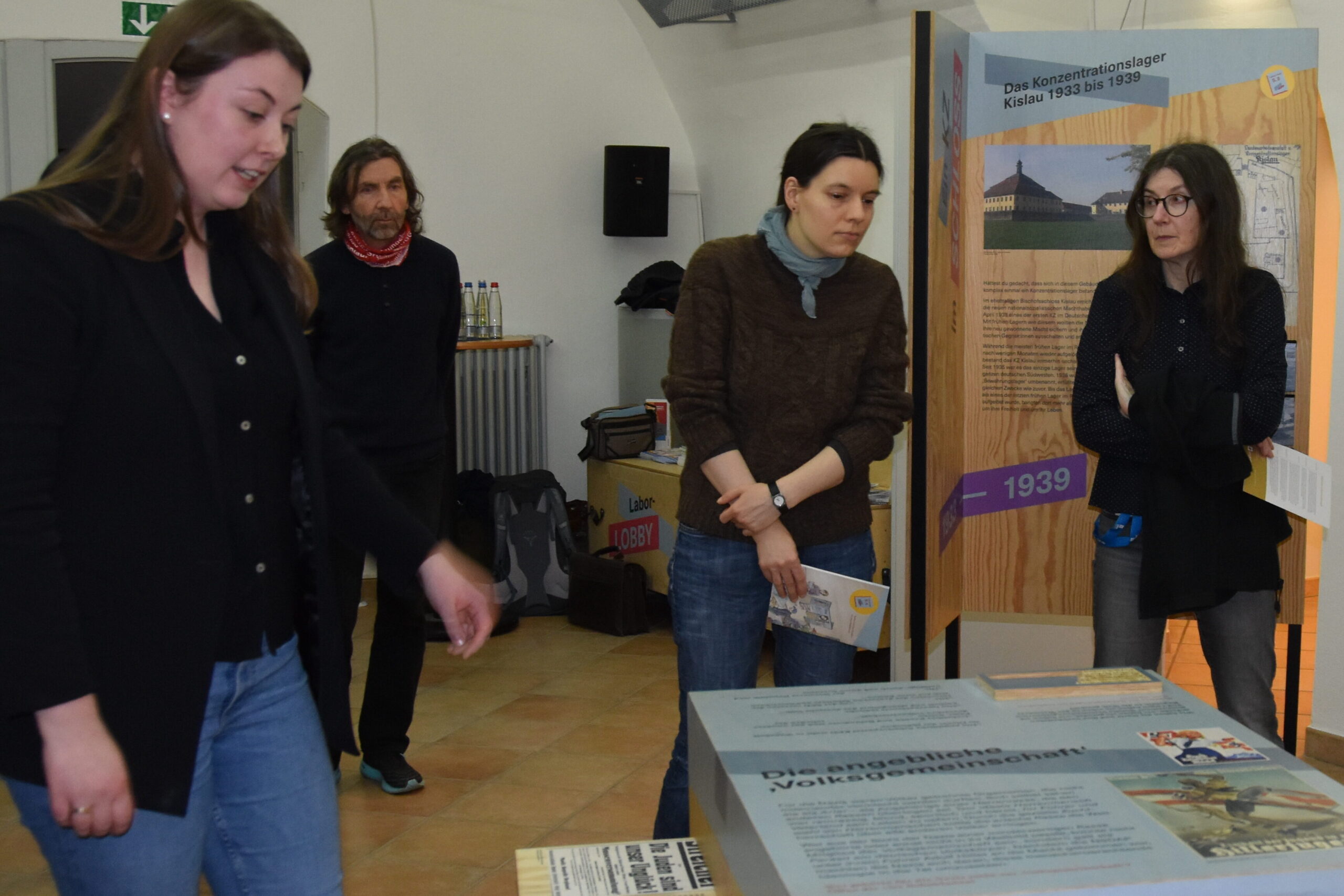 Eine Frau erklärt Publikum eine Station zur "Volkgsemeinschaft" in der Ausstellung "Wo fängt Unrecht an? Das mobile Geschichtslabor zum KZ Kislau"